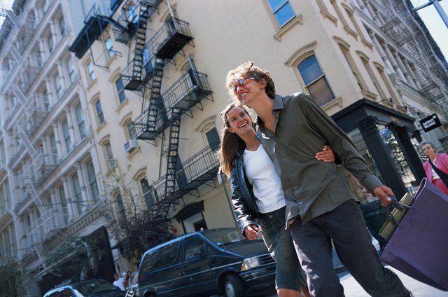 Couple holding shopping bags, walking on road