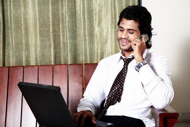 Young man using laptop and mobile phone