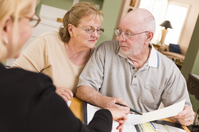 Senior Adult Couple Going Over Papers in Home with Agent