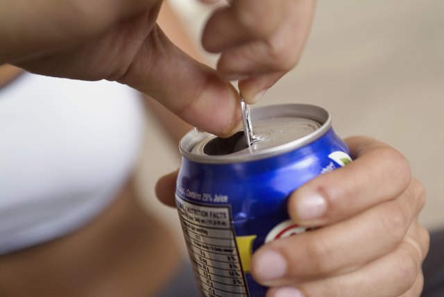 Extreme close-up of woman opening canned drink, focus on foreground