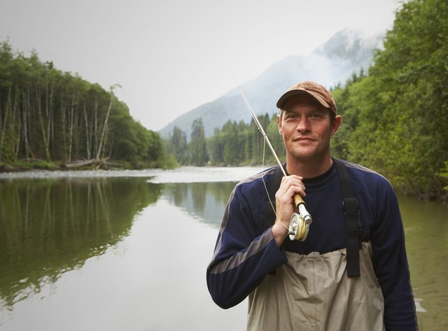 Portrait of fly fisherman standing in river