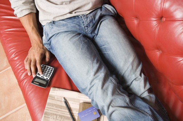Man with stock market newspaper and calculator