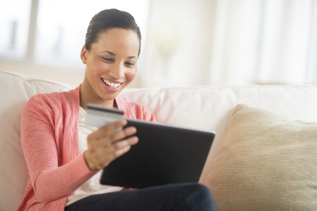 Woman With Credit Card And Laptop Shopping Online At Home