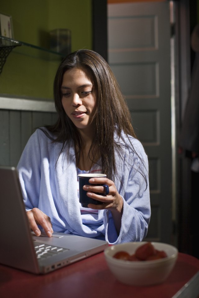 girl using computer over breakfast