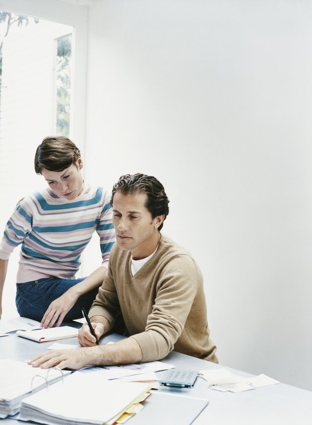 Couple Sat at a Table Calculating Their Personal Finances