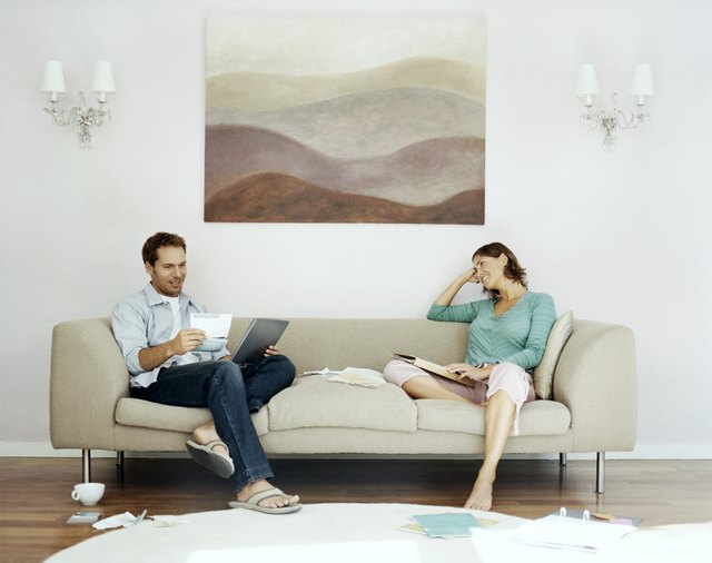 Couple Sits on Sofa Examing Their Bills