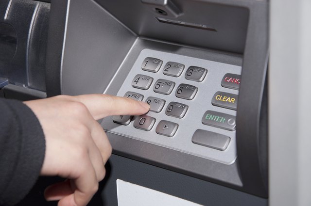 Woman pressing number button on ATM machine