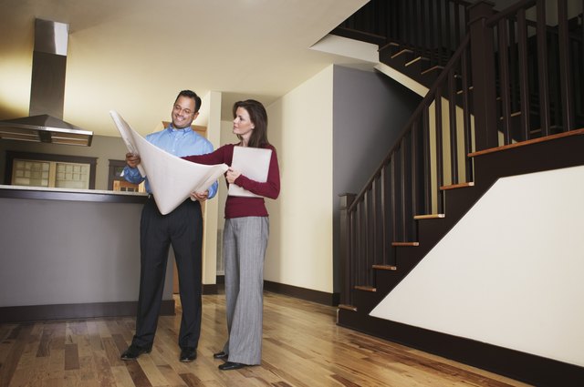 Man and woman looking at blueprint of house